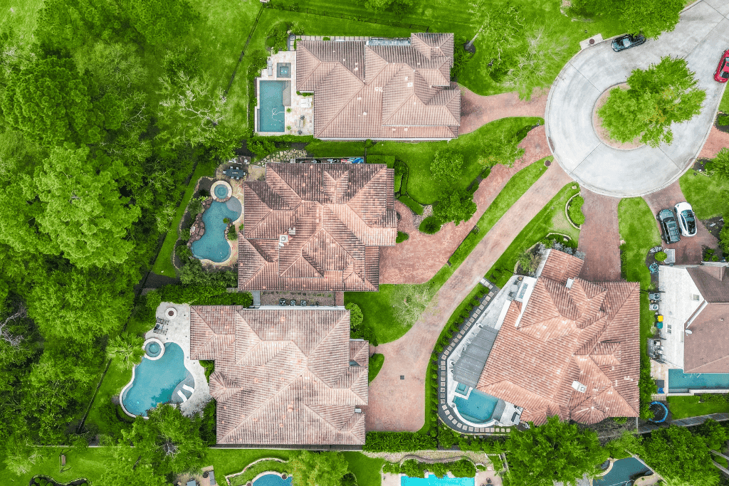 Overhead drone photograph showing estate homes, pools, driveways, and property layout in Cypress, Texas.