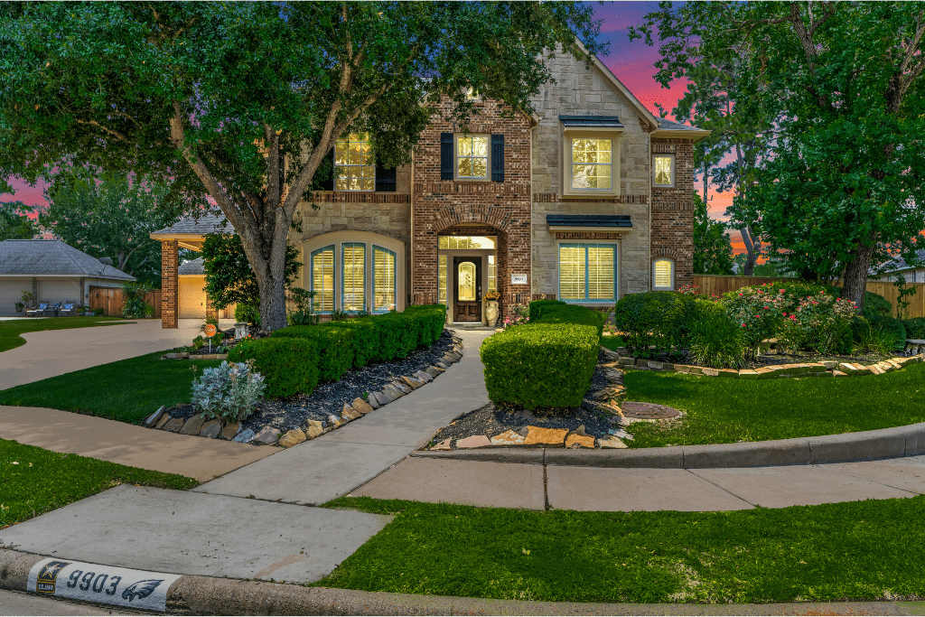 Twilight real estate photography of a Houston-area home with glowing interior lights.