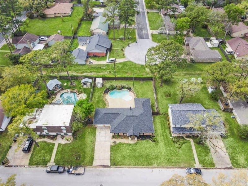 Aerial real estate photography of a Tomball-area home with a larger lot and surrounding trees